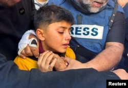 FILE - Brother of Palestinian journalist Hamza Al-Dahdouh, the son of Al Jazeera journalist Wael Al-Dahdouh, attends his funeral, after Hamza was killed in an Israeli strike, in Rafah in the southern Gaza Strip, January 7, 2024.