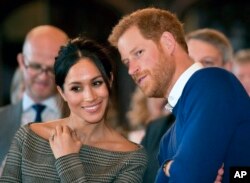 FILE - Britain's Prince Harry and Meghan Markle watch a dance performance by Jukebox Collective Cardiff Castle in Cardiff, Wales, Jan. 18, 2018.