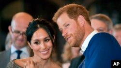 FILE - Britain's Prince Harry and Meghan Markle watch a dance performance by Jukebox Collective Cardiff Castle in Cardiff, Wales, Jan. 18, 2018. 