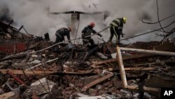Firefighters work to extinguish a fire after a Russian attack destroyed the building of a Culinary School in Kharkiv, Apr. 12, 2022. 