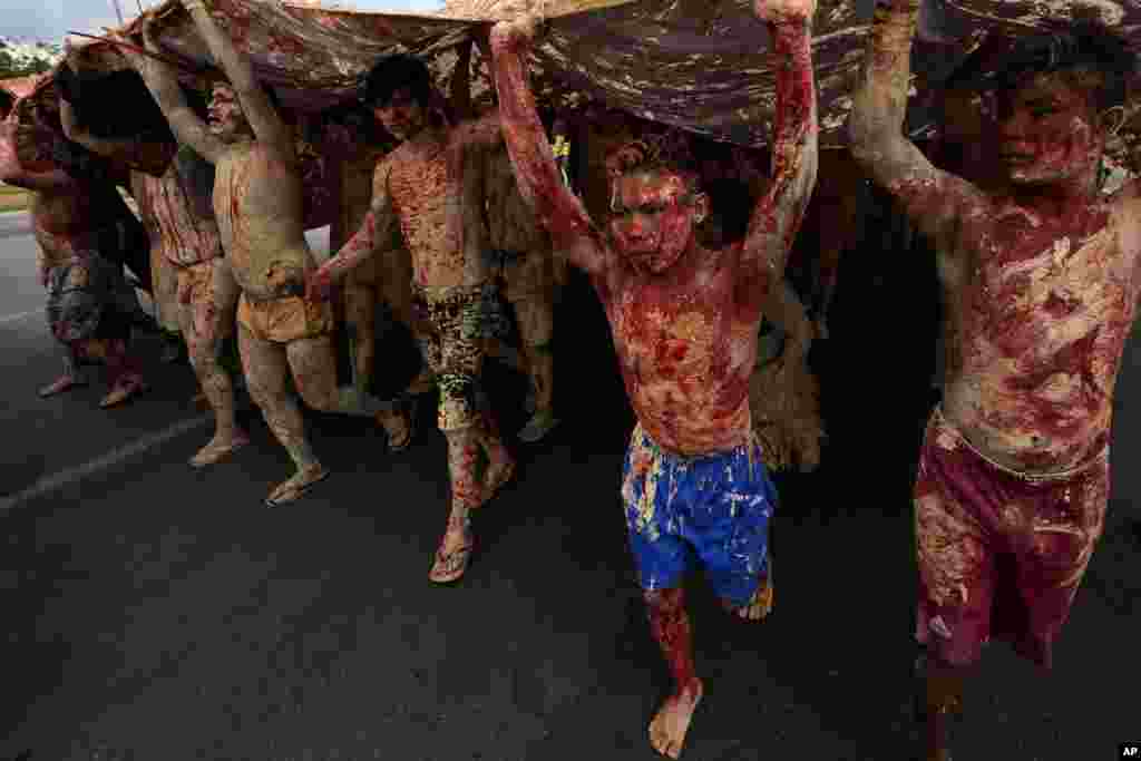 Indigenous people, painted with red ink representing spilled Indigenous blood and clay representing gold, march during a protest against the increase of mining activities on their land, in front of the Ministry of Mines and Energy in Brasilia, Brazil.