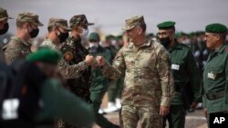 
On June 18, 2021, Gen. Stephen J. Townsend, head of the United States Africa Command, center, arrives alongside General Belkhir el-Farouk, Right, Moroccan Southern Zone Commander, to his right, to watch the African Lion military exercise.