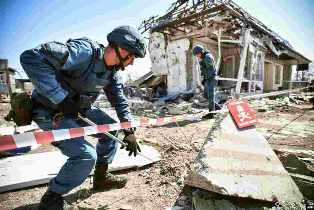 Limpiadores de minas rusos buscan objetos explosivos en un edificio que, según las autoridades rusas, fue dañado por los bombardeos ucranianos el 11 de abril de 2022, en Volnovakha, en la autoproclamada República Popular de Donetsk.