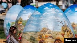 A girl looks at two-meter-high Easter eggs painted in the traditional art style in Koprivnica, Croatia.