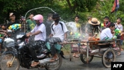 ប្រជាពលរដ្ឋខ្មែរបាញ់ទឹកដាក់គ្នា ក្នុងឱកាសអបអរសាទរពិធីបុណ្យចូលឆ្នាំខ្មែរ នៅតាមដងផ្លូវ ក្នុងខេត្តសៀមរាប ថ្ងៃទី ១៤ ខែមេសា ឆ្នាំ ២០២២។ (Photo by TANG CHHIN Sothy / AFP) 