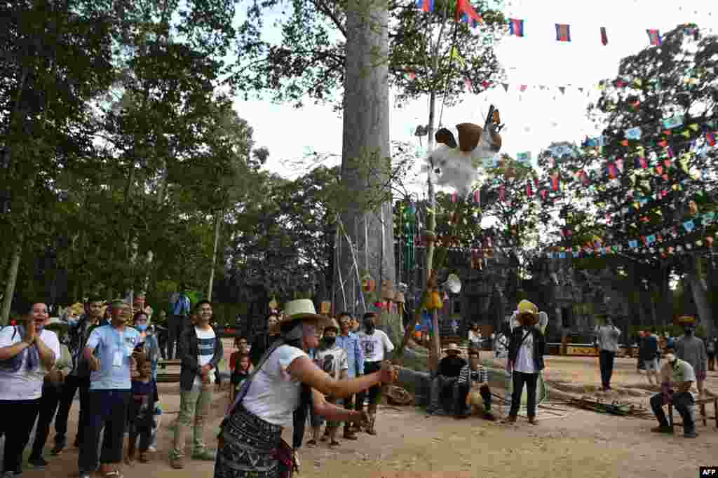 A woman plays a game during Khmer New Year celebrations at Chau Say Tevoda temple in Siem Reap province on April 14, 2022.