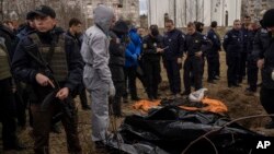 Pripadnici francuske žandarmerije posmatraju eshumaciju civila ubijenih tokom ruske okupacije Buče, gradića u predgrađu Kijeva, Ukrajina, 12. aprila 2022.