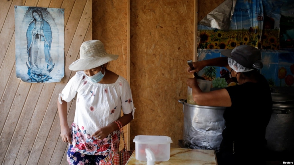 A woman is attended to in a soup kitchen in Pamplona Alta, a low-income neighborhood, in Lima, Peru April 11, 2022. (REUTERS/Daniel Becerril)