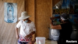 Seorang perempuan bertugas di dapur sup di Pamplona Alta, yang merupakan wilayah miskin di Lima, Peru, pada 11 April 2022. (Foto: Reuters/Daniel Becerril)