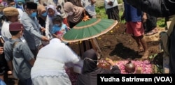 Keluarga dan kerabat menaburkan bunga di makam Haekal, putra diplomat Indonesia, di Boyolali Jawa tengah, Kamis (14/4). (VOA/ Yudha Satriawan)