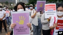 Activists hold posters reading "stop sexual violence" and "free Indonesia from sexual violence", during a rally commemorating the International Women's Day in Jakarta, Indonesia, Tuesday, March 8, 2022. 