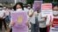 Activists hold posters reading "stop sexual violence" and "free Indonesia from sexual violence", during a rally commemorating the International Women's Day in Jakarta, Indonesia, Tuesday, March 8, 2022. 