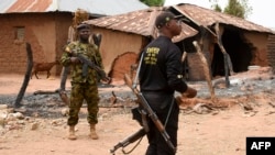 Le personnel de sécurité monte la garde dans le village de Kukawa, dans la zone du gouvernement local de Kanam, dans l'État du Plateau, le 12 avril 2022, après que les maisons des résidents ont été incendiées lors d'une attaque de bandits.
