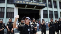 Un estudiante de magisterio protesta frente a la Corte de Constitucionalidad que es protegida por la policía, mientras participa de una marcha contra la privatización de la educación en Ciudad de Guatemala, el 26 de abril de 2007. 