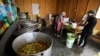 Florinda Salazar dan Elena Rodriguez menyiapkan makanan di dapur sup tempat mereka bekerja di Pamplona Alta, sebuah wilayah miskin di Lima, Peru, pada 11 April 2022. (Foto: Reuters/Daniel Becerril)