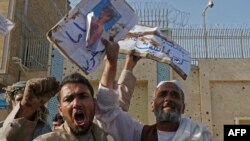 Sejumlah warga Afghanistan meneriakkan slogan-slogan saat demo memprotes laporan penyiksaan terhadap pengungsi Afghanistan di Iran, di luar konsulat Iran di Herat, 11 April 2022. (Foto: Mohsen Karimi/AFP)