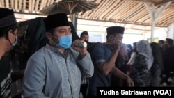 Diplomat Indonesia, Harun Syaifullah Syafa (baju dan masker biru) mengusung jenazah putranya Haekal saat prosesi pemakaman di Boyolali, Kamis (14/4). Haekal menjadi korban kecelakaan di Amerika Serikat. (VOA/ Yudha Satriawan)