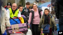 La gente regresa a Ucrania por el cruce fronterizo en Medyka, sureste de Polonia, el sábado 9 de abril de 2022.