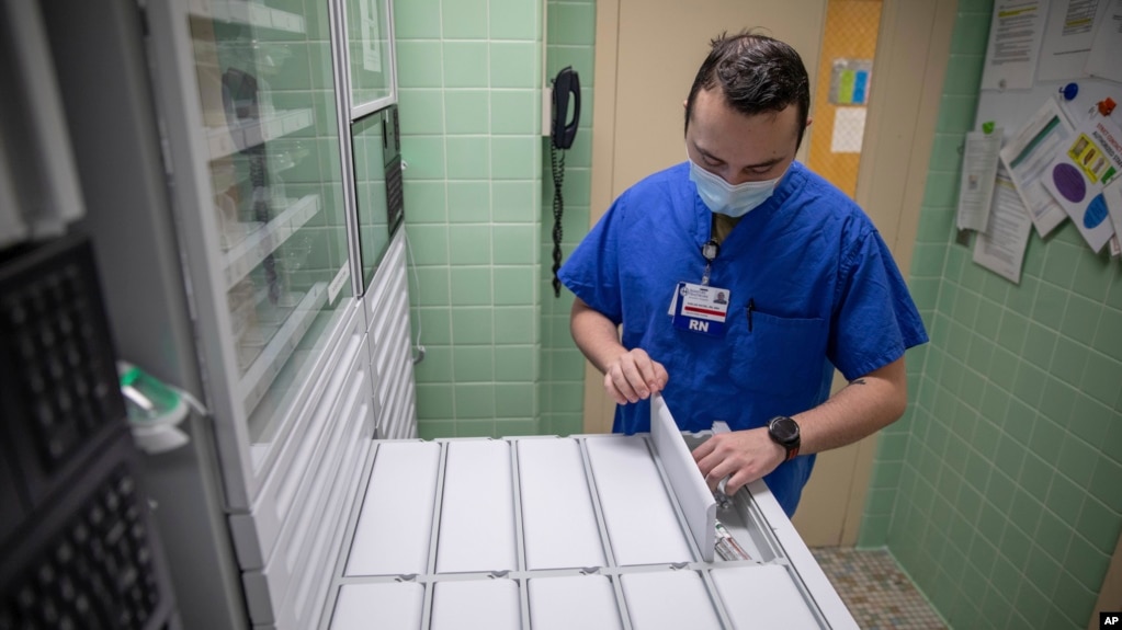 U.S. Air Force 2nd Lt. Kaelan Hayes, a clinical nurse assigned to the military medical team deployed to Brockton, Mass., gathers medication as part of the COVID-19 response operations at Signature Healthcare Brockton Hospital, March 15, 2022. (Sgt. Kaden D. Pitt/U.S. Army via AP)