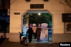 A blocked off gate with a photo of a police officer is seen at an entrance to a residential area under lockdown, amid the COVID-19 pandemic, in Shanghai, China, April 11, 2022.