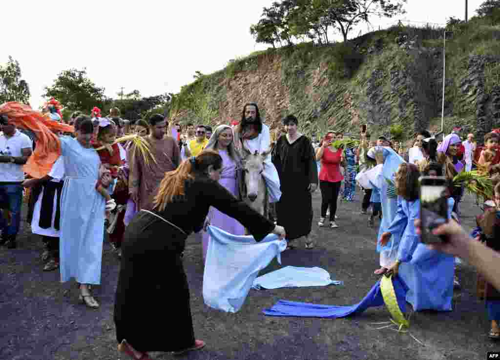 Fieles católicos participan en la recreación de la entrada de Jesucristo en Jerusalén, durante la procesión del Domingo de Ramos, que marca el inicio de la Semana Santa, en Cerro Nemby, en las afueras de Asunción, Paraguay, el 10 de abril de 2022.
