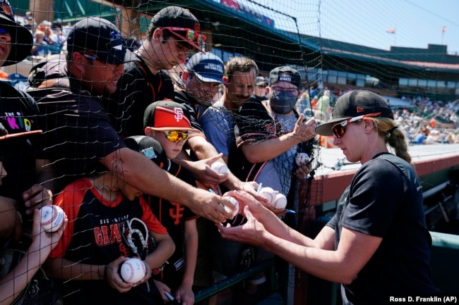 FILE - San Francisco Giants assistant coach Alyssa Nakken signs autographs for fans prior to a spring training baseball game against the Colorado Rockies Thursday, March 31, 2022, in Scottsdale, Arizona. (AP Photo/Ross D. Franklin)