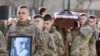 Hermanos de armas del militar Taras Bobanych, quien murió durante el conflicto con Rusia, llevan su retrato y ataúd durante su ceremonia fúnebre en el cementerio Lychakiv en la ciudad de Lviv, en el oeste de Ucrania, en abril. 13, 2022.