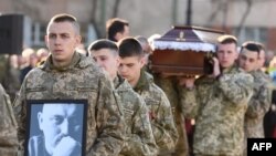 Hermanos de armas del militar Taras Bobanych, quien murió durante el conflicto con Rusia, llevan su retrato y ataúd durante su ceremonia fúnebre en el cementerio Lychakiv en la ciudad de Lviv, en el oeste de Ucrania, en abril. 13, 2022.