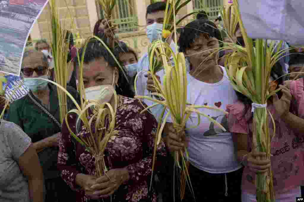 Fieles católicos participan en la tradicional procesión del Domingo de Ramos en el centro histórico de San Salvador, el 10 de abril de 2022.