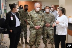 In this image provided by the U.S. Army, University of Utah Health staff speak with the U.S. Army North personnel in Salt Lake City, Utah, March 2, 2022, during a visit to the University of Utah Hospital. (Pfc. Duke Edwards/U.S. Army via AP)