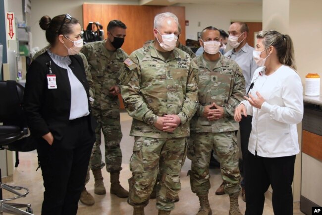 In this image provided by the U.S. Army, University of Utah Health staff speak with the U.S. Army North personnel in Salt Lake City, Utah, March 2, 2022, during a visit to the University of Utah Hospital. (Pfc. Duke Edwards/U.S. Army via AP)