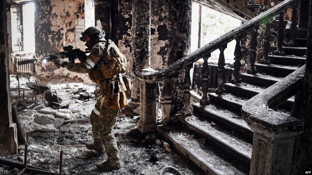 A Russian soldier patrols at the Mariupol drama theater that was bombed last March 16, in Mariupol. This picture was taken during a trip organized by the Russian military on April 12, 2022. (Photo by Alexander NEMENOV / AFP)
