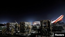 FILE - Ukrainian service members unpack Javelin anti-tank missiles, delivered by plane as part of the U.S. military support package for Ukraine, at the Boryspil International Airport outside Kyiv, Ukraine, Feb. 10, 2022.