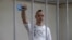 FILE - Ivan Safronov, a former journalist and an aide to the head of Russia's space agency Roscosmos who remains in custody on state treason charges, gestures inside a defendants' cage as he attends a court hearing in Moscow, Russia, Sept. 2, 2020. 