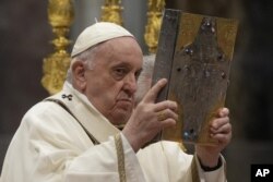 Paus Fransiskus membawa Injil selama misa di Basilika Santo Petrus di Vatikan pada 14 April 2022. (Foto: AP)