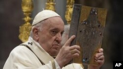 El papa Francisco muestra el Evangelio durante una misa en la basílica de San Pedro, en el Vaticano, el 14 de abril de 2022. (AP Foto/Gregorio Borgia)