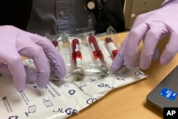 Vials of blood from a participant in a clinical study of the effectiveness of a new liquid biopsy technology are packaged for shipment at Oregon Health & Science University in Portland, Ore., on March 14, 2022. (AP Photo/Gillian Flaccus)