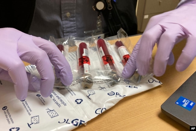 Vials of blood from a participant in a clinical study of the effectiveness of a new liquid biopsy technology are packaged for shipment at Oregon Health & Science University in Portland, Ore., on March 14, 2022. (AP Photo/Gillian Flaccus)