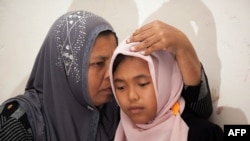 Indonesian mother Jamaliah (L) hugs her daughter Raudhatul Jannah (R) after they were reunited in Meulaboh, Aceh province, August 7, 2014.