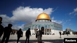 La gente camina junto la Cúpula de la Roca en el complejo conocido para los judíos como Templo del Monte y para los musulmanes como Noble Santuario en la ciudad vieja de Jerusalén el 31 de enero de 2020.