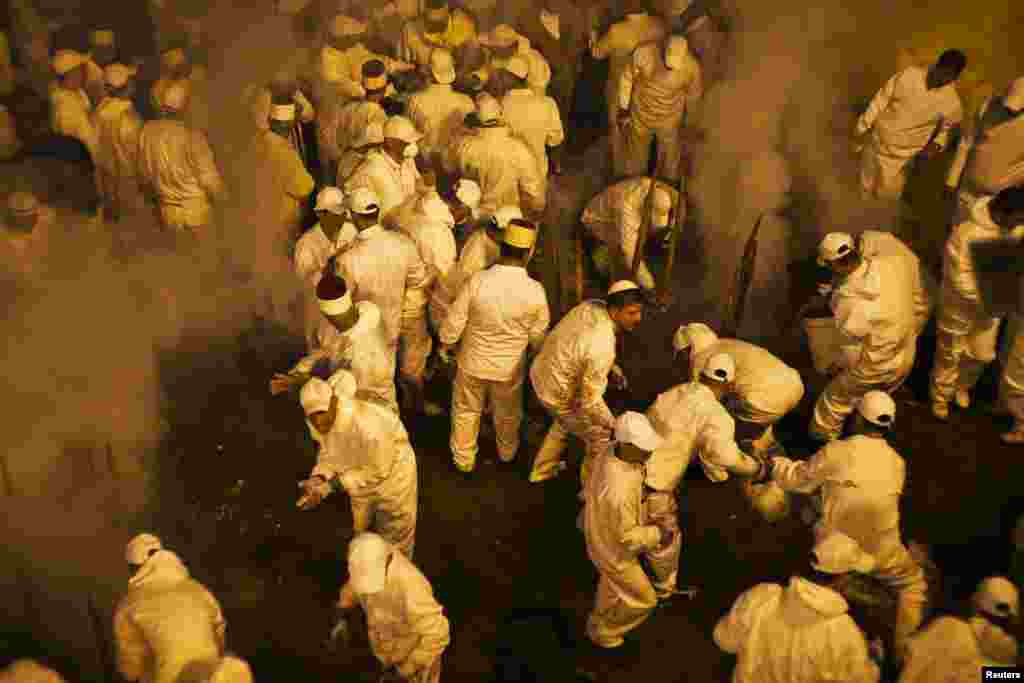 Members of the Samaritan sect seal an oven after filling it with large sheep on skewers during a traditional Passover sacrifice ceremony on Mount Gerizim, near the West Bank city of Nablus, Apr. 23, 2013.