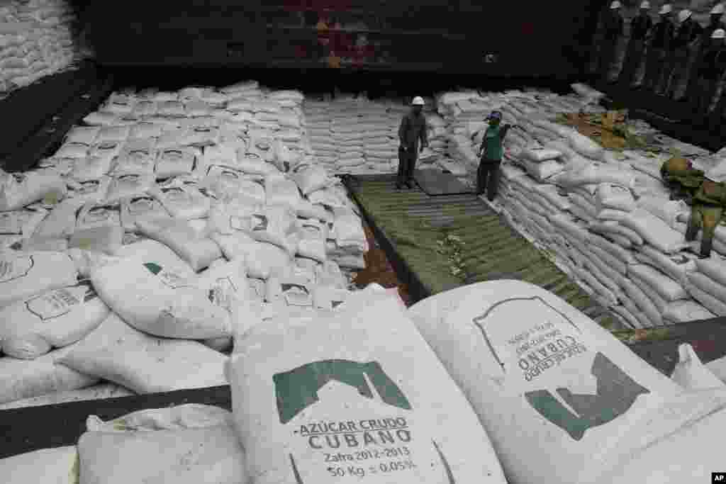 Trabajadores panameños descargan del azúcar cubano que ocultaba contenedores con armas en un barco norcoreano proveniente de La Habana y con destino a Corea del Norte. El carguero permanece detenido en Panamá. (AP Photo/Arnulfo Franco)