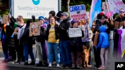 FILE - Transgender rights supporters protest outside of Seattle Children's Hospital after it postponed some gender-affirming surgeries for minors following an executive order by President Donald Trump, Feb. 9, 2025, in Seattle.