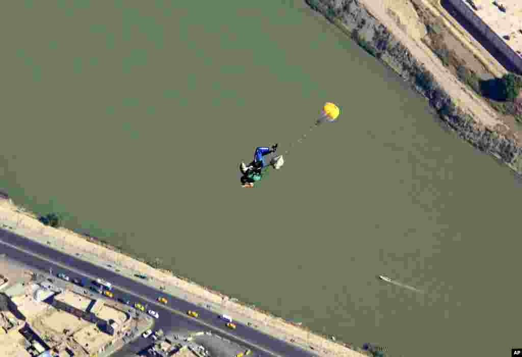 With the Tigris River beneath him, a member of Iraq's national skydiving national team parachutes over the capital during a training session in Baghdad, Friday, Sept. 27, 2013.