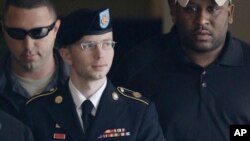 FILE - Army Pfc. Bradley Manning is escorted to a security vehicle outside a courthouse in Fort Meade, Maryland, after a hearing in his court martial, Aug. 20, 2013.