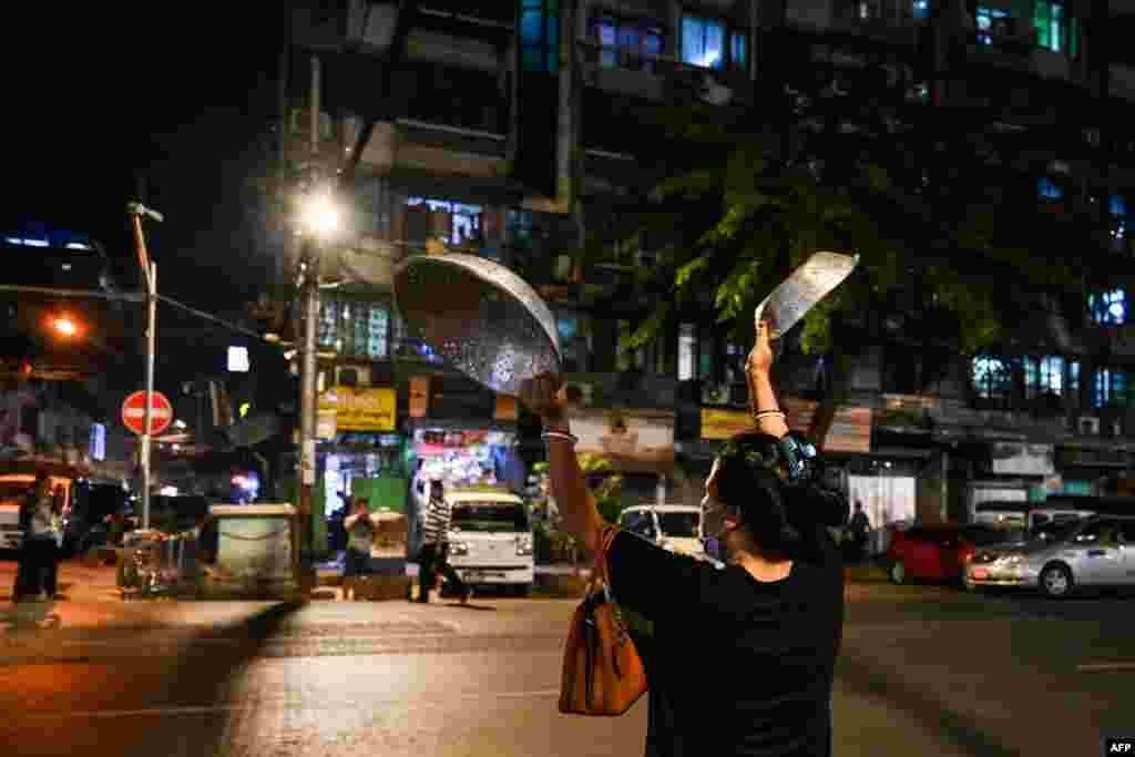A woman clatters pans to make noise after calls for protest went out on social media in Yangon as Myanmar&#39;s ousted leader Aung San Suu Kyi was formally charged two days after she was detained in a military coup.