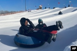 Nawal Hirsi, right, goes snow tubing with her family as part of a group promoting outdoors activities by Muslim women, at Elm Creek Park Reserve in Maple Grove, Minn., on Jan. 4, 2025.