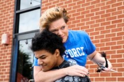 Kelly Moïse, Ibu Kieran Moïse, terharu memeluk anaknya saat acara pemotongan rambut untuk "Kieran's Curls for Cancer."