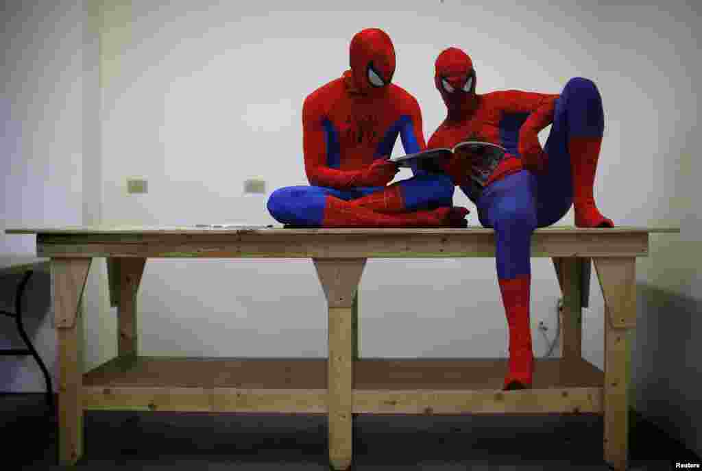 Peter Norbot and Kris Hamilton (L), dressed up as fictional comic book superhero Spider-Man, look through a magazine as they wait for their turn to audition to be a part of a promotional campaign for the upcoming release of the new movie &quot;The Amazing Spider-Man 2&quot; in Chicago, USA, Mar. 19, 2014.