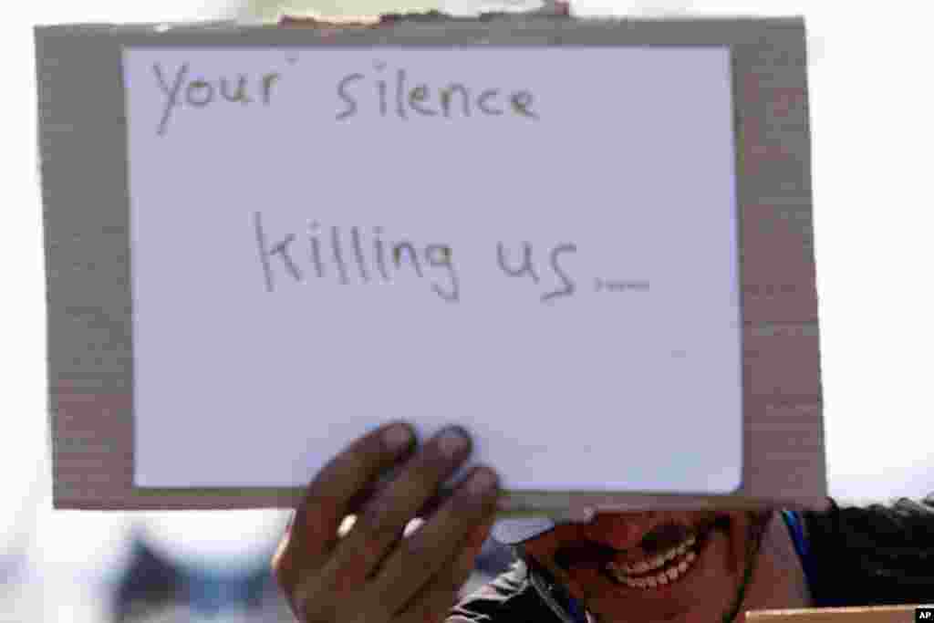 A migrant holds a banner reading "Your silence killing us " during a demonstration on rail tracks at the northern Greek border point of Idomeni.